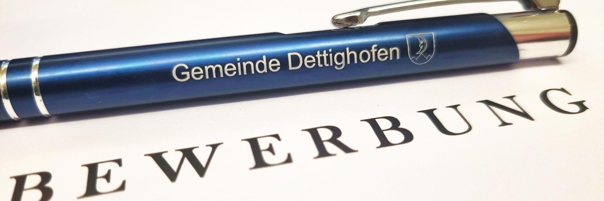 Eine Fotografie eines Kugelschreibers mit dem Logo der Gemeinde Dettighofenn auf einem Blatt mit dem Wort Bewerbung
