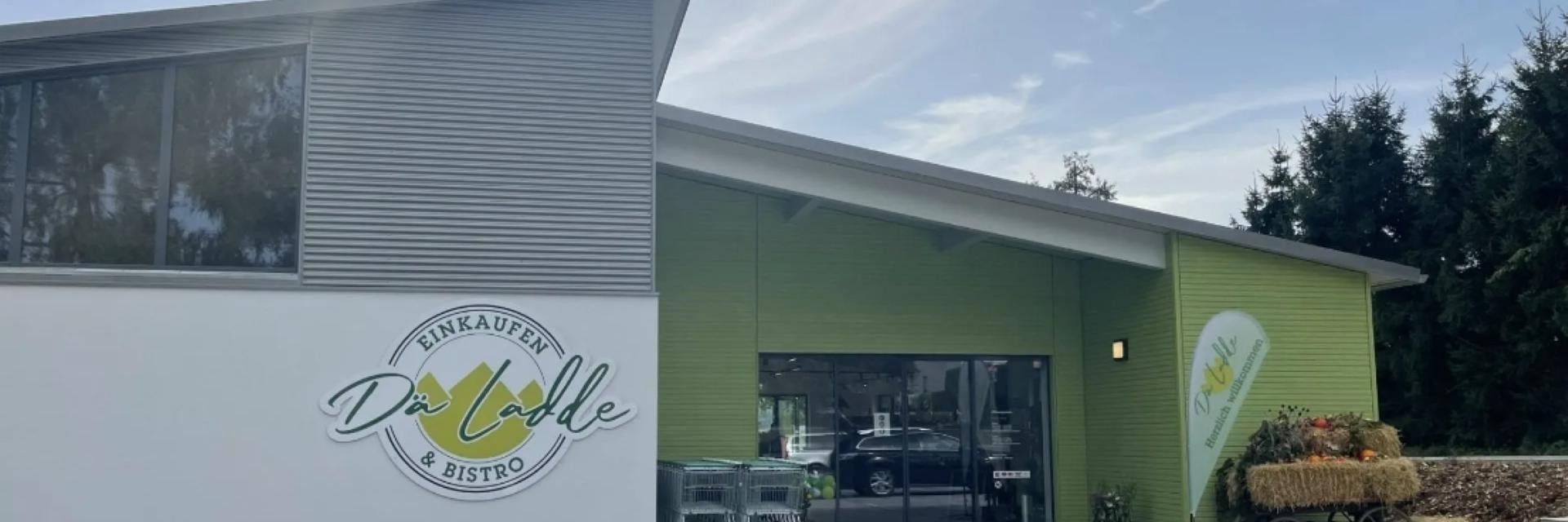 Der Eingang des Dorfladens, in einem lebhaften Grünton gehalten, zieht die Aufmerksamkeit der Kunden auf sich.